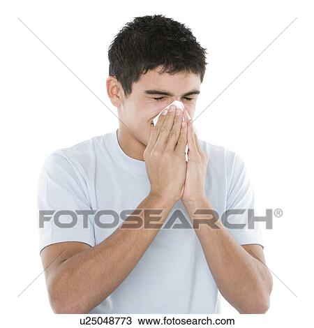 Stock Image - Teenage boy sneezing. Fotosearch