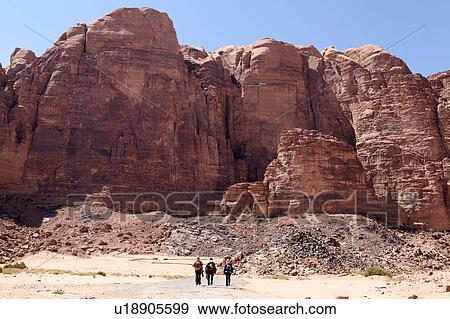 Stock Photo - Three hikers hiking in Wadi Rum, Jordan. Fotosearch