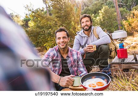 Three men frying eggs on camping stove in forest, Deer Park, Cape Town, South Africa View Large Photo Image Stock Image - Three men frying eggs on camping stove in forest, Deer Park, Cape Town, South Africa. Fotosearch