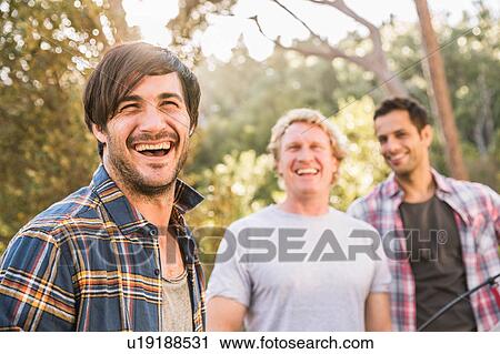 Three men laughing whilst putting up tent in forest, Deer Park, Cape Town, South Africa View Large Photo Image Stock Image - Three men laughing whilst putting up tent in forest, Deer Park, Cape Town, South Africa. Fotosearch