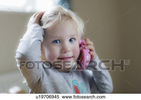 Stock Photography - Toddler playing with toy phone. Fotosearch