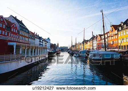 Stock Photo - Traditional townhouses and moored boats on canal waterfront, Copenhagen, Denmark. Fotosearch