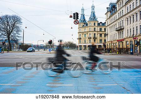Two cyclists speeding along blue city cycle path, Copenhagen, Denmark View Large Photo Image Stock Photo - Two cyclists speeding along blue city cycle path, Copenhagen, Denmark. Fotosearch