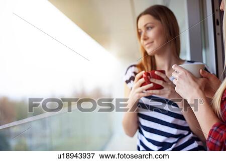 Stock Photo - Two female friends, drinking coffee, outdoors. Fotosearch