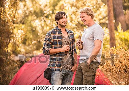 Two male campers chatting and drinking beer in forest, Deer Park, Cape Town, South Africa View Large Photo Image Stock Photograph - Two male campers chatting and drinking beer in forest, Deer Park, Cape Town, South Africa. Fotosearch