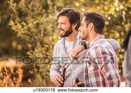 Stock Photo - Two men drinking beer in forest, Deer Park, Cape Town, South Africa. Fotosearch