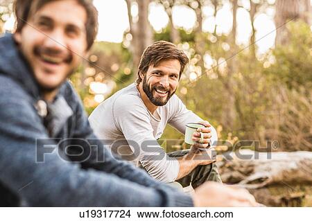 Two men drinking coffee whilst sitting in forest, Deer Park, Cape Town, South Africa View Large Photo Image Picture - Two men drinking coffee whilst sitting in forest, Deer Park, Cape Town, South Africa. Fotosearch