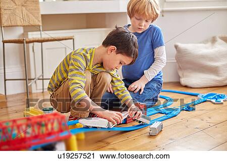 Two young boys playing with toy train set View Large Photo Image Stock Image - Two young boys playing with toy train set. Fotosearch