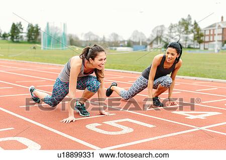 Two young women in starting position on running track View Large Photo Image Stock Image - Two young women in starting position on running track. Fotosearch