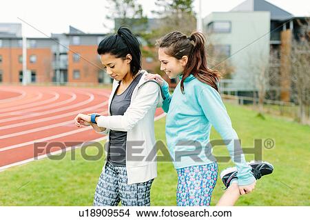Two young women outdoors, exercising, stretching View Large Photo Image Picture - Two young women outdoors, exercising, stretching. Fotosearch