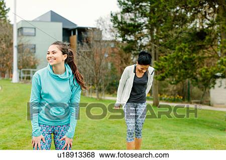 Stock Photo - Two young women outdoors, exercising. Fotosearch