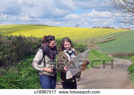 Two young women standing on country road, looking at map View Large Photo Image Stock Photo - Two young women standing on country road, looking at map. Fotosearch