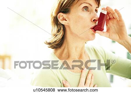 Stock Photo - Using asthma inhaler. Fotosearch