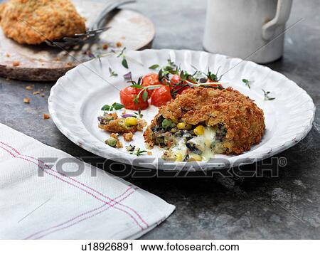 Stock Image - Vegetarian kiev on plate with tomatoes. Fotosearch