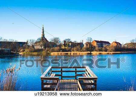 View of wooden pier on river and distant church spire, Copenhagen, Denmark View Large Photo Image Stock Photo - View of wooden pier on river and distant church spire, Copenhagen, Denmark. Fotosearch