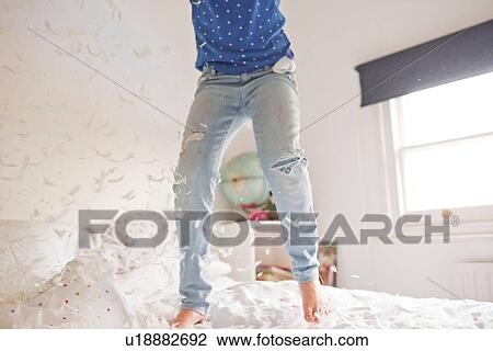 Waist down of girl jumping and feather pillow fighting on bed View Large Photo Image Stock Image - Waist down of girl jumping and feather pillow fighting on bed. Fotosearch