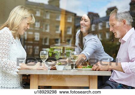 Stock Photo - Waitress serving lunch to mature dating couple at restaurant table, London, UK. Fotosearch