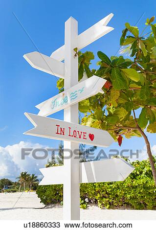 Stock Image - White tourist direction sign on beach, Dominican Republic, The Caribbean. Fotosearch