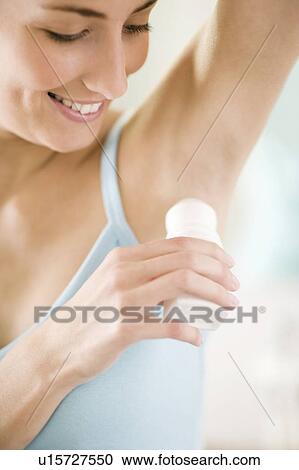 Stock Image - Woman applying deodorant. Fotosearch