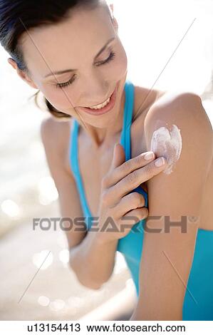Woman applying sunscreen View Large Photo Image Stock Image - Woman applying sunscreen. Fotosearch