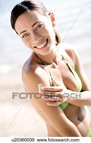 Stock Photo - Woman applying sunscreen. Fotosearch