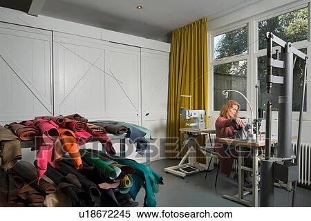 Stock Photography - Woman at sewing machine in workshop. Fotosearch
