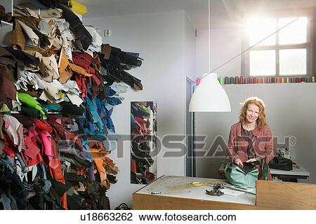 Woman at workbench in workshop assembling leather holdall View Large Photo Image Stock Image - Woman at workbench in workshop assembling leather holdall. Fotosearch