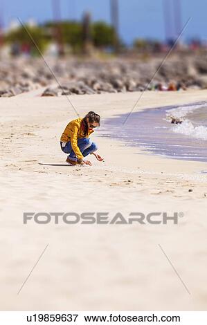 Stock Photo - Woman collecting shells. Fotosearch