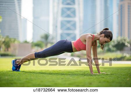 Woman doing push ups in park, Dubai, United Arab Emirates View Large Photo Image Picture - Woman doing push ups in park, Dubai, United Arab Emirates. Fotosearch