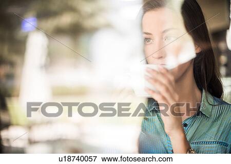 Woman drinking coffee at reflective cafe window, Dubai, United Arab Emirates View Large Photo Image Stock Photo - Woman drinking coffee at reflective cafe window, Dubai, United Arab Emirates. Fotosearch