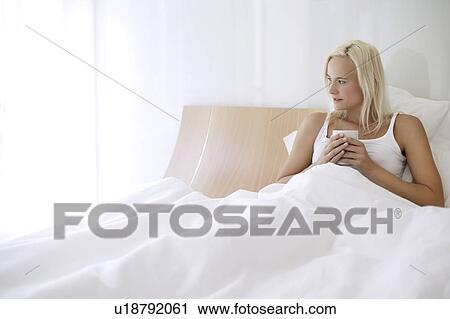 Woman drinking tea in bed View Large Photo Image Stock Image - Woman drinking tea in bed. Fotosearch