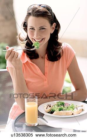 Stock Photography - Woman eating a salad. Fotosearch
