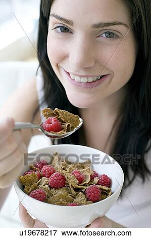 Stock Photo - Woman eating healthy cereal. Fotosearch