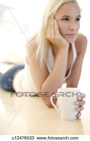 Stock Image - Woman holding a cup of tea. Fotosearch