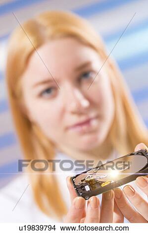 Woman holding a hard disc drive View Large Photo Image Picture - Woman holding a hard disc drive. Fotosearch