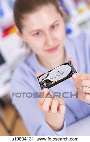 Stock Image - Woman holding a hard disc drive. Fotosearch