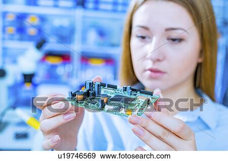 Stock Photo - Woman holding a printed circuit board. Fotosearch