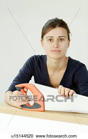 Stock Image - Woman holding a saw. Fotosearch