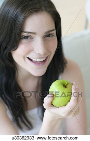 Stock Image - Woman holding an apple. Fotosearch
