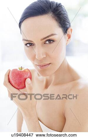 Stock Photo - Woman holding an apple. Fotosearch
