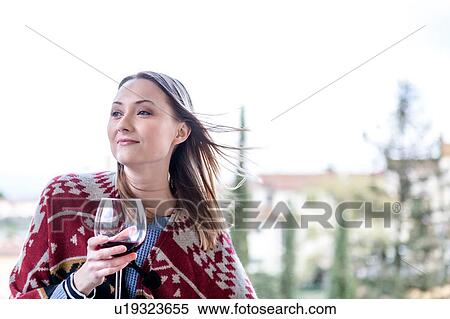 Woman holding glass of red wine looking away smiling View Large Photo Image Stock Photography - Woman holding glass of red wine looking away smiling. Fotosearch