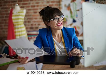 Woman in design studio holding paperwork using computerised sketch pad smiling View Large Photo Image Stock Image - Woman in design studio holding paperwork using computerised sketch pad smiling. Fotosearch