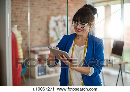 Woman in design studio using digital tablet smiling View Large Photo Image Stock Image - Woman in design studio using digital tablet smiling. Fotosearch