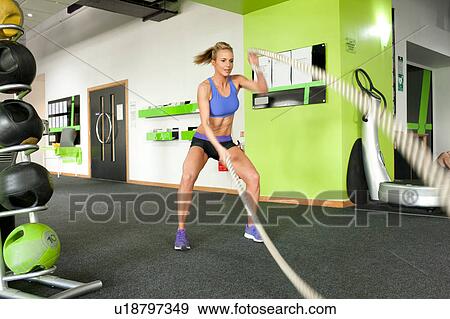 Woman in gym using gym ropes View Large Photo Image Stock Photo - Woman in gym using gym ropes. Fotosearch