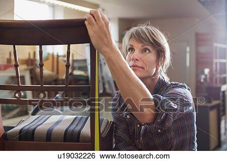 Woman in workshop measuring chair with tape measure View Large Photo Image Stock Photograph - Woman in workshop measuring chair with tape measure. Fotosearch