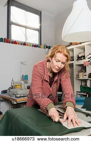 Woman in workshop trimming leather skin View Large Photo Image Stock Image - Woman in workshop trimming leather skin. Fotosearch