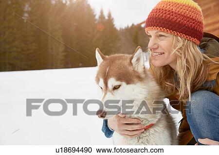 Woman kneeling with husky in snow covered landscape, Elmau, Bavaria, Germany View Large Photo Image Stock Image - Woman kneeling with husky in snow covered landscape, Elmau, Bavaria, Germany. Fotosearch