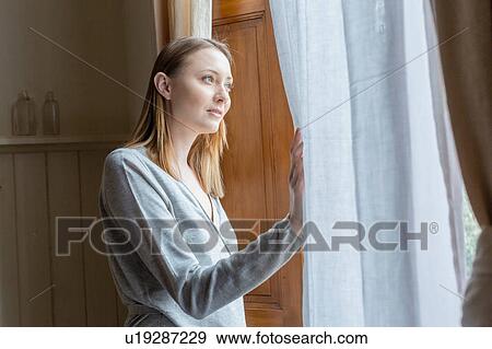 Woman looking out of window View Large Photo Image Stock Photo - Woman looking out of window. Fotosearch