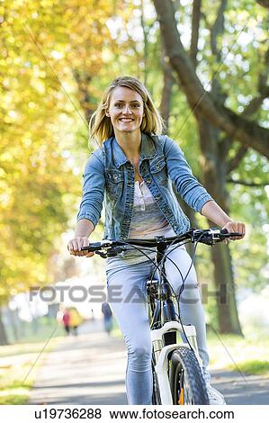 Woman riding a bicycle View Large Photo Image Stock Photo - Woman riding a bicycle. Fotosearch