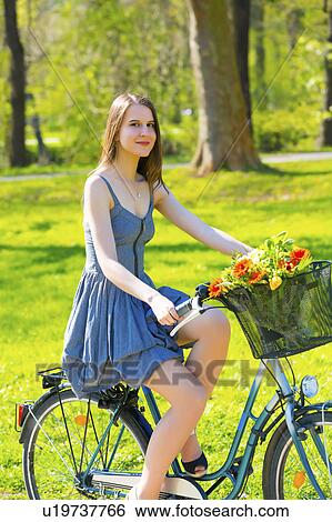 Woman riding bicycle in park View Large Photo Image Stock Photograph - Woman riding bicycle in park. Fotosearch